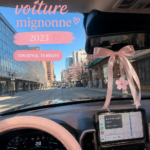 Une voiture décorée avec des accessoires mignons et roses, créant une ambiance esthétique