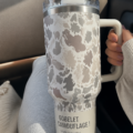 Une tasse Stanley au motif camouflage exposée sur une table en bois.