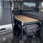 Ford Tourneo Custom aménagé pour les voyages, offrant un espace chaleureux et fonctionnel.