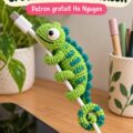 Un protège-câble crocheté motif caméléon sur une table en bois